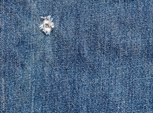 Texture of torn denim in closeup.