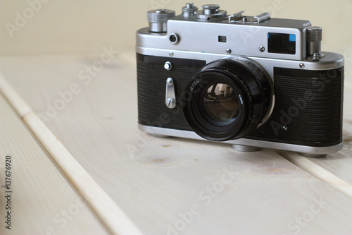 Film retro camera on a wooden table, retro concept, light background