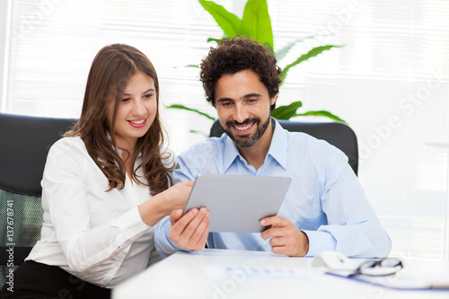 Two young business partners discussing plans or ideas at meeting photo