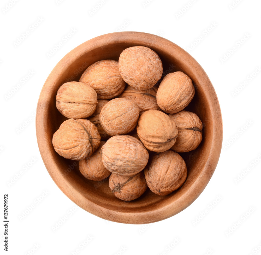 Walnuts in wooden plate isolated on white Walnuts in wooden plate isolated on white