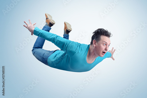 Fototapeta Crazy man in shirt and jeans is flying in the sky. Jumper concept