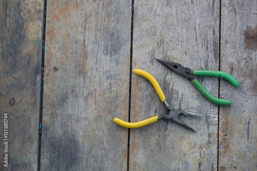 2 pairs of jewelry pliers on an old wooden table