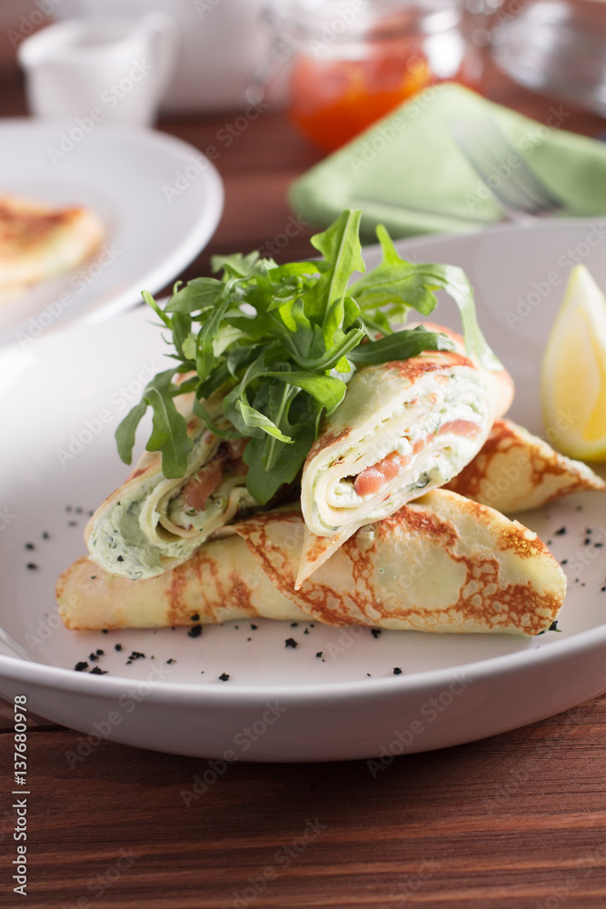 Healthy Breakfast, pancakes with salmon, cheese mousse, herbs, on a wooden table. Selective focus Healthy Breakfast, pancakes with salmon, cheese mousse, herbs, on a wooden table. Selective focus