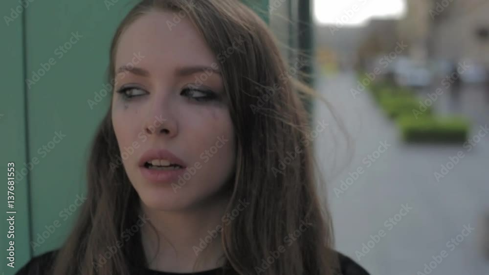 Beautiful sad woman crying in the city. Slow motion. Messy make up mascara on face. Beautiful sad woman crying in the city. Slow motion. Messy make up mascara on face.