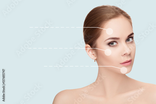 Spa portrait of young, beautiful woman with dotted arrows on fac