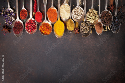 Various spices spoons on stone table. Top view