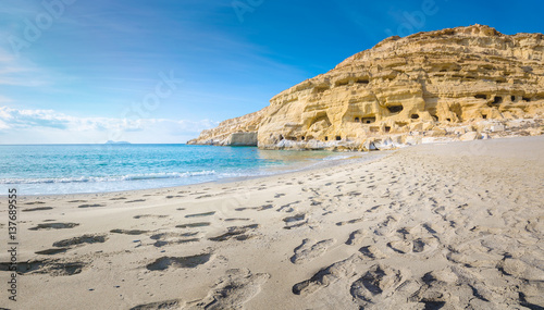 Panorama of Matala beach with the caves on the rocks that were used as a roman cemetery and at the decade of 70's were living hippies from all over the world, Crete, Greece
