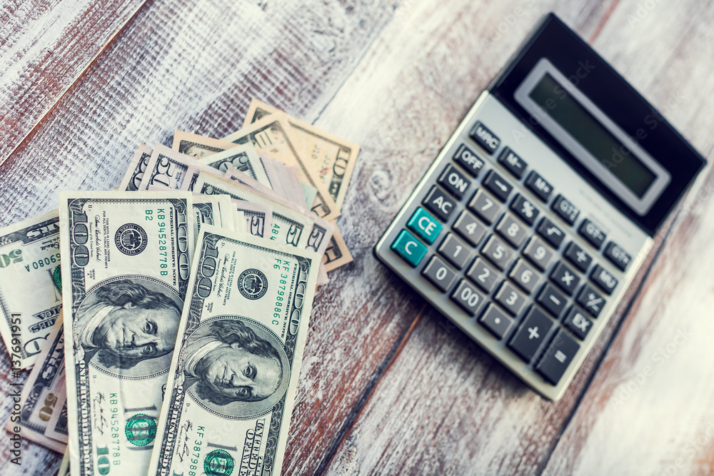 calculator the American dollars isolated on a wooden background calculator the American dollars isolated on a wooden background