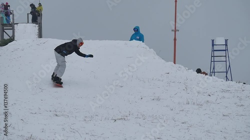 Snowboarder at jump inhigh mountains at sunny photo