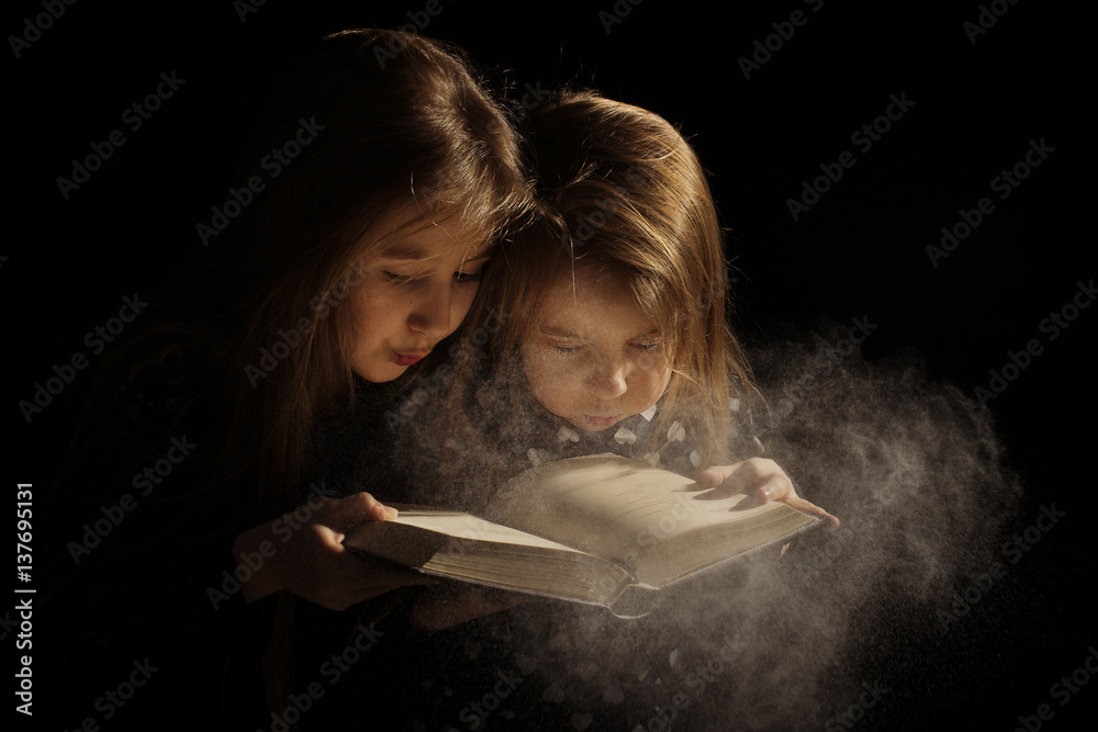 Obraz na płótnie dziewczynki z zakurzoną książką w salonie