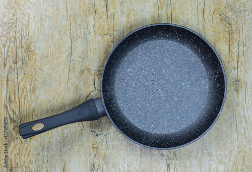 New frying pan on a wooden background