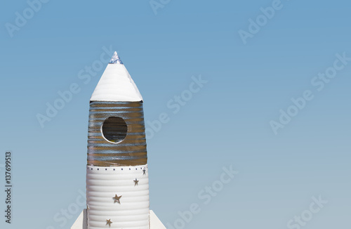 Big hand made toy rocket standing outdoor against sky