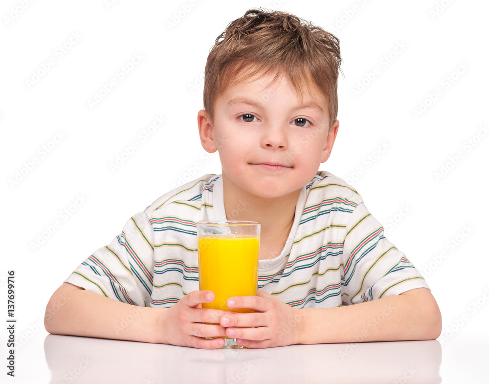 Portrait of happy little boy drinking refreshing orange juice. Smiling child with glass of fresh lemonade.