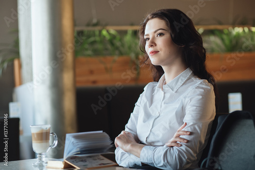 Young businesswoman sitting in cafe, relaxing, and waiting her order
