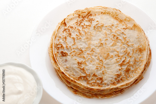 Tableau sur toile Pancakes with sour cream on a white background