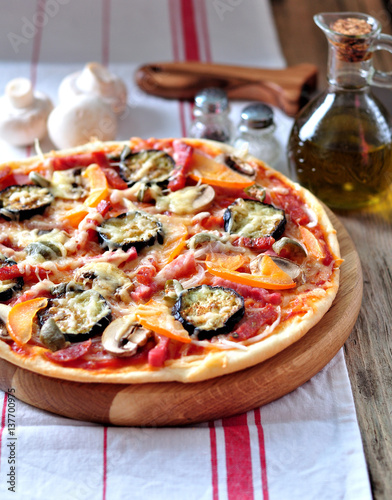 Homemade pizza with eggplant, ham, chorizo, mushrooms, onions and cheese.