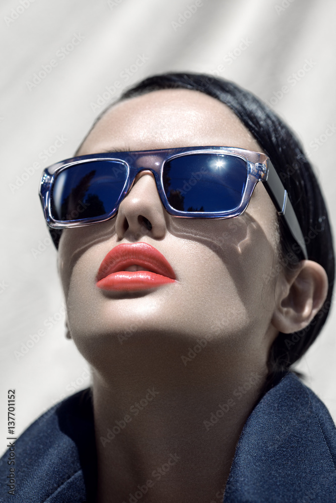 Fashion outdoor portrait of a young beautiful brunette girl in sunglasses with stylish hairstyle. Fashion outdoor portrait of a young beautiful brunette girl in sunglasses with stylish hairstyle.