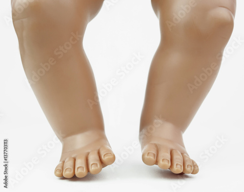 Isolated baby doll's feet, legs and knees.