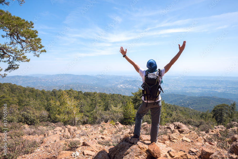 Happy man with backpack stands on a rocky slope Happy man with backpack stands on a rocky slope