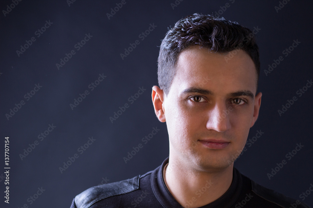 Obraz premium Close-up portrait of black-haired man on black background