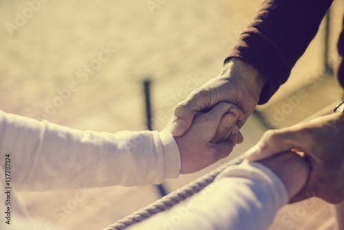 Closeup on couple in love Valentine day background. Happy lovers holding hands together with sunny outdoors.