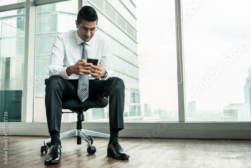 Tableau sur toile Businessman using a mobile phone while sitting down