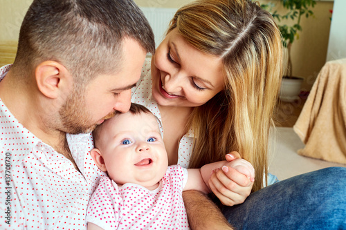 A happy family. Mom and Dad with baby in the room.