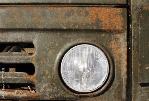 old car headlights. Rusty hood close up. Radiator grille