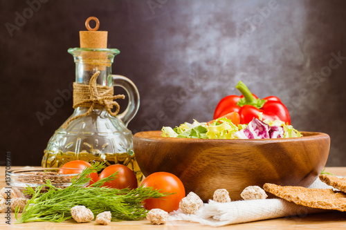 Fototapeta Naklejka Na Ścianę i Meble -  Натюрморт с салатом, овощами, зеленью, оливковым маслом, зерновыми хлебцами и отрубями