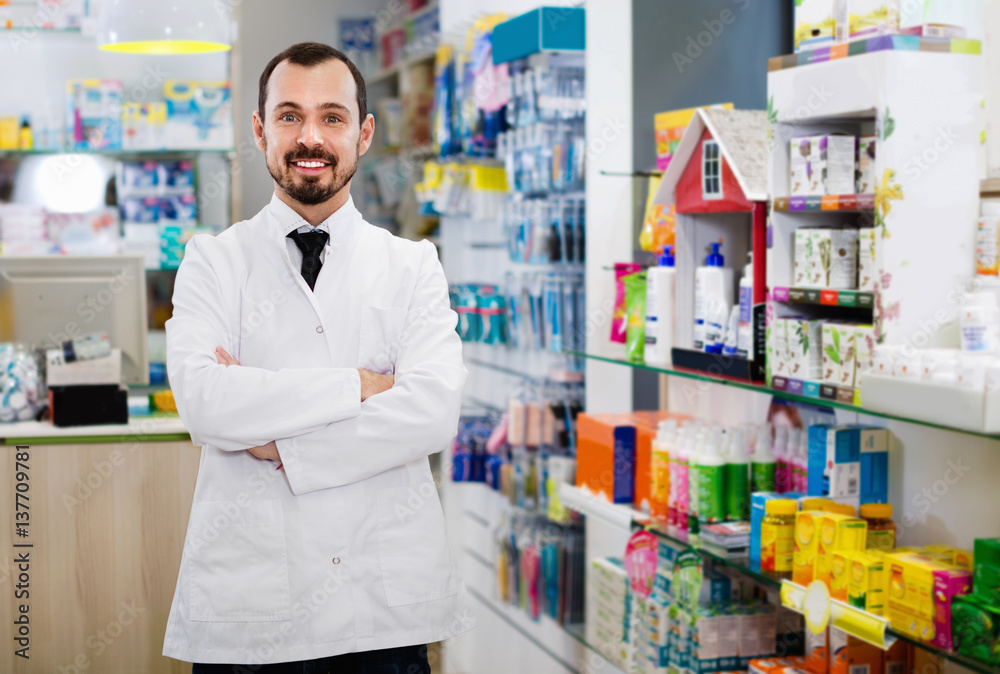 Male pharmacist demonstrating assortment of drugs