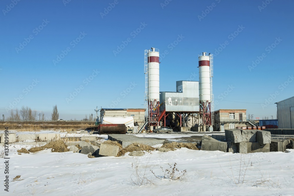 Obraz premium Exterior view of a cement factory. Concrete mixing silo, site construction facilities.