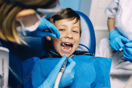 Dentists with a patient during a dental intervention to boy.
