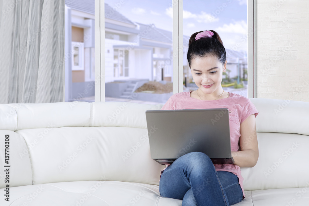 Beautiful woman uses laptop computer at home Beautiful woman uses laptop computer at home