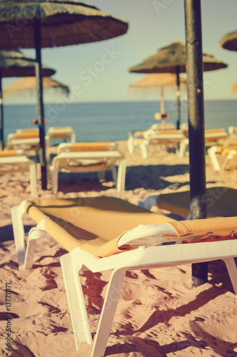 Straw umbrellas on ocean beach in Algarve Portugal  sunny outdoors background