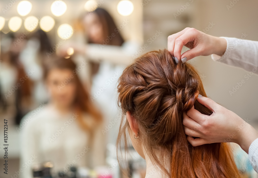Beautiful, red-haired girl with long hair, hairdresser weaves a French braid, in a beauty salon. Professional hair care and creating hairstyles. Beautiful, red-haired girl with long hair, hairdresser weaves a French braid, in a beauty salon. Professional hair care and creating hairstyles.