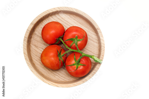 bunch of red tomatoes isolated on a white background.wooden plate.top view