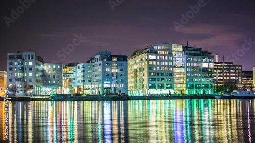 Time Lapse of office buildings at night. Light reflections in the water