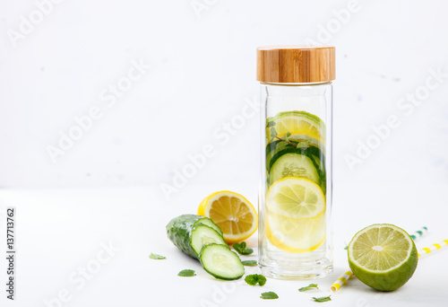 Detox Infused Water with Lemon, Lime,Cucumber and Mint in Sports Glass Bottle on a White Background.Healthy Beverage.Food  diet concept.Vegetarian.Copy space for Text. selective focus.