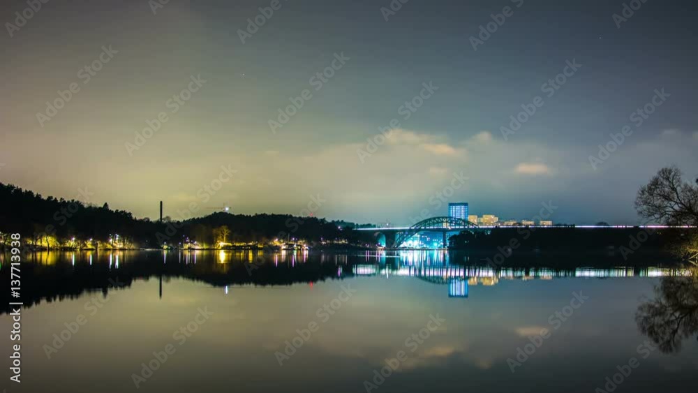 Time Lapse of calm lake and railway bridge at night. Reflections in the water Time Lapse of calm lake and railway bridge at night. Reflections in the water