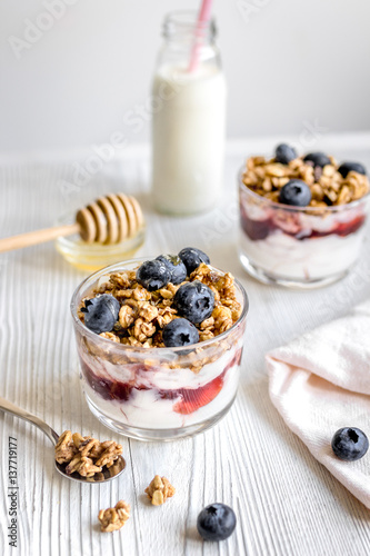 Morning granola with yogurt and berries on white kitchen background