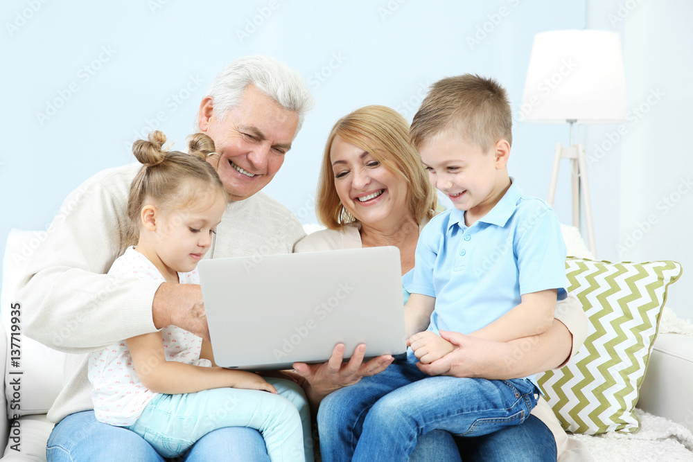 Children and grandparents using laptop at home Children and grandparents using laptop at home