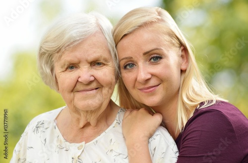Obraz na płótnie Grandmother and granddaughter. Young woman carefully takes care of an older woman. w salonie