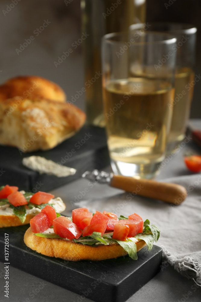 Delicious toasts with tomatoes and creamy cheese on wooden board