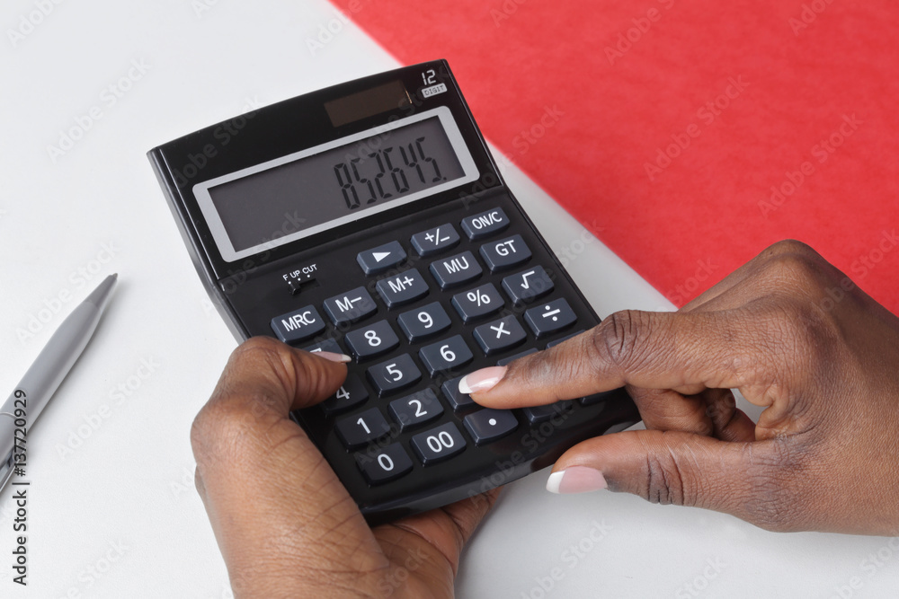 main femme noire tapant sur une calculatrice de bureau main femme noire tapant sur une calculatrice de bureau