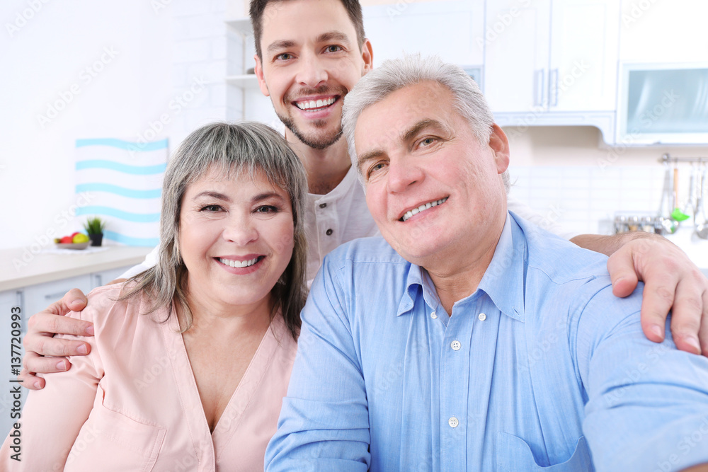 Young man with middle aged parents taking selfie Young man with middle aged parents taking selfie