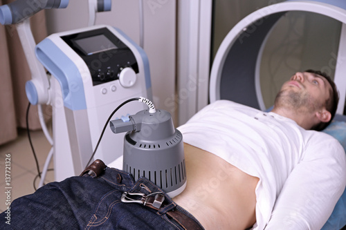 Inductive shortwave diathermy for young man in modern clinic