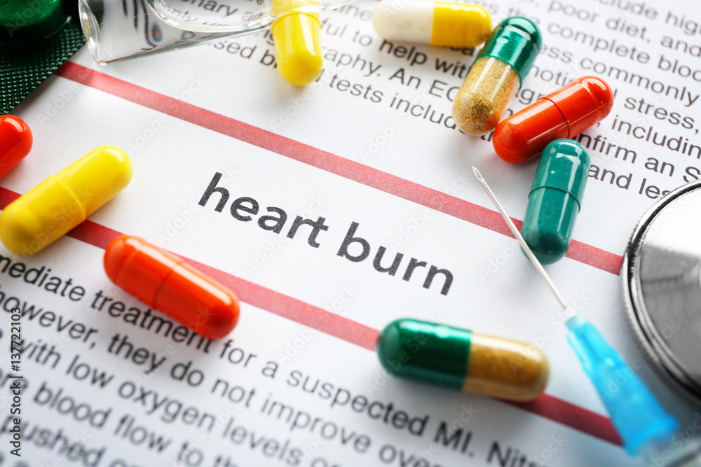 Obraz premium Phrase HEART BURN in center of medicines