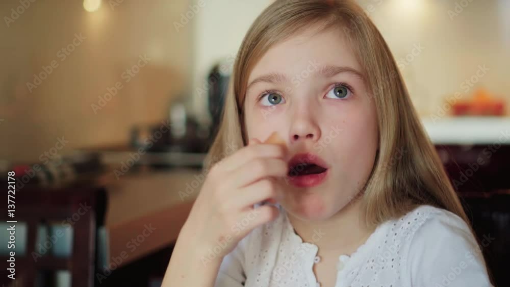 Close up portrait child girl 8 years old eating sausage Close up portrait child girl 8 years old eating sausage