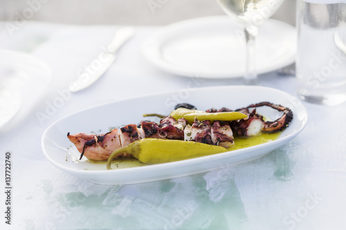 Grilled Octopus, Mediterranean cuisine, sea food, seafood restaurant. Traditional Greek cuisine. Octopus and pepper marinated with olive oil and spices.

