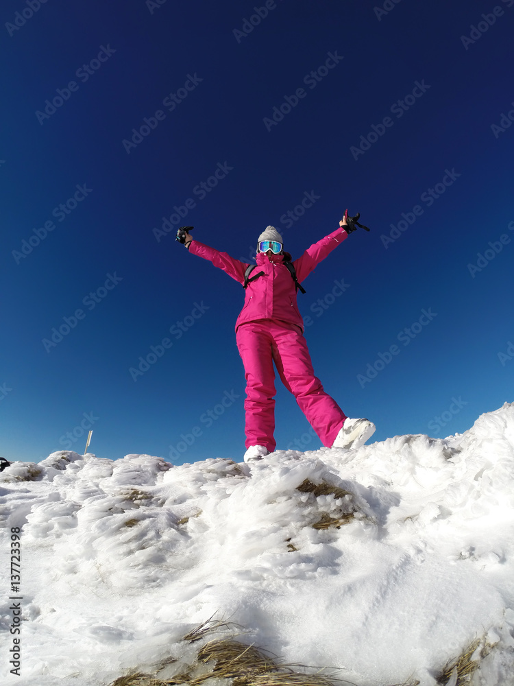 Young skier on the top of snowy mountain